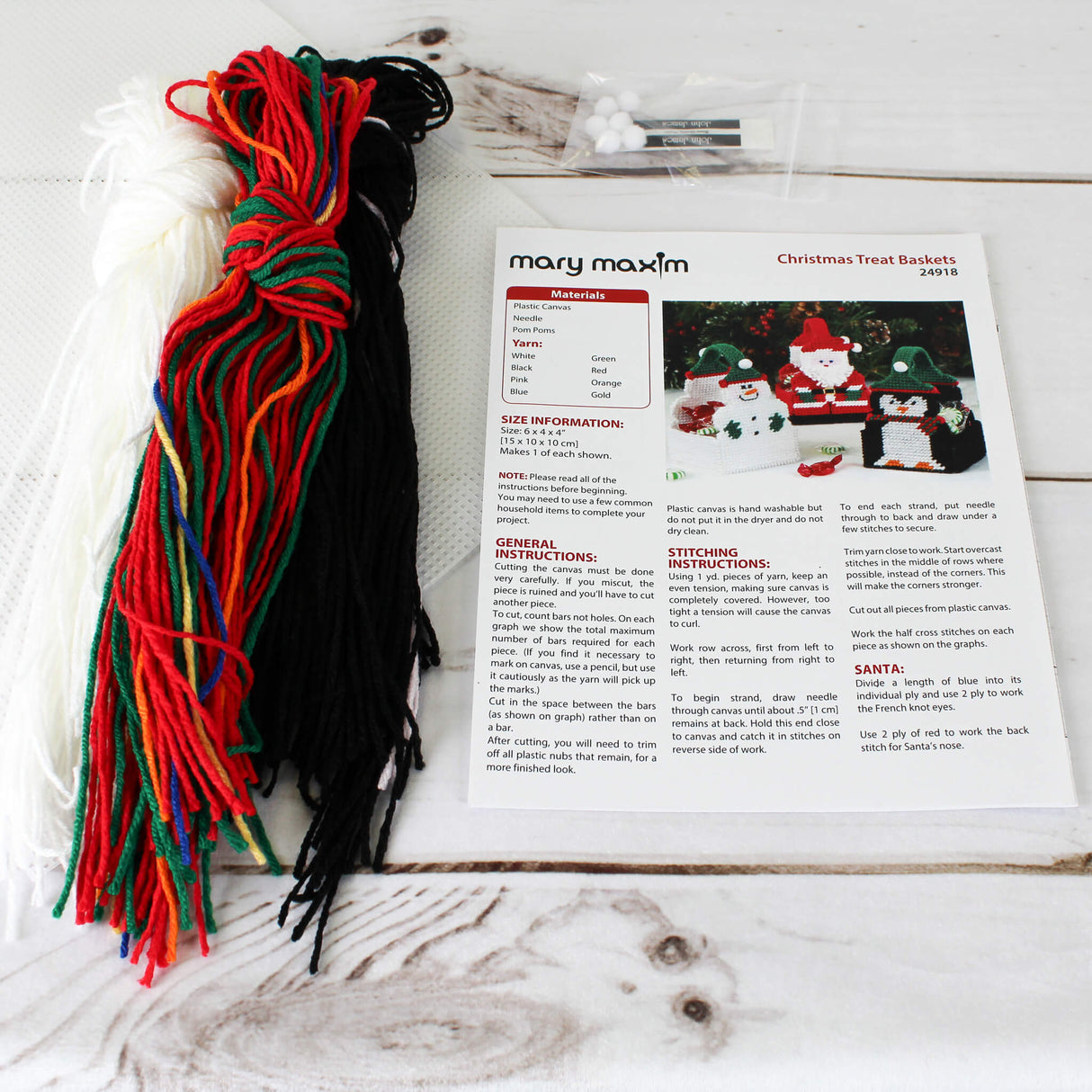 Plastic Canvas Treat Basket 3D Kit of Santa, Snowman, and Penguin wearing hats and mittens.