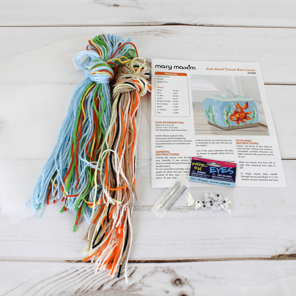 Plastic Canvas Tissue Box Cover shaped like a fishbowl with a fancy goldfish with green and yellow seaweed and bubbles.