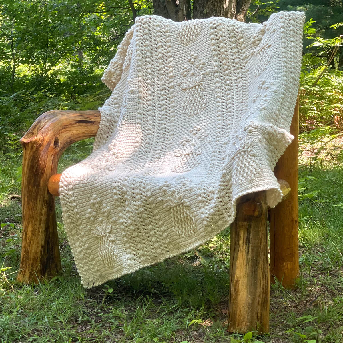 Pineapple and Floral Shoppe Afghan on a wooden chair in the woods