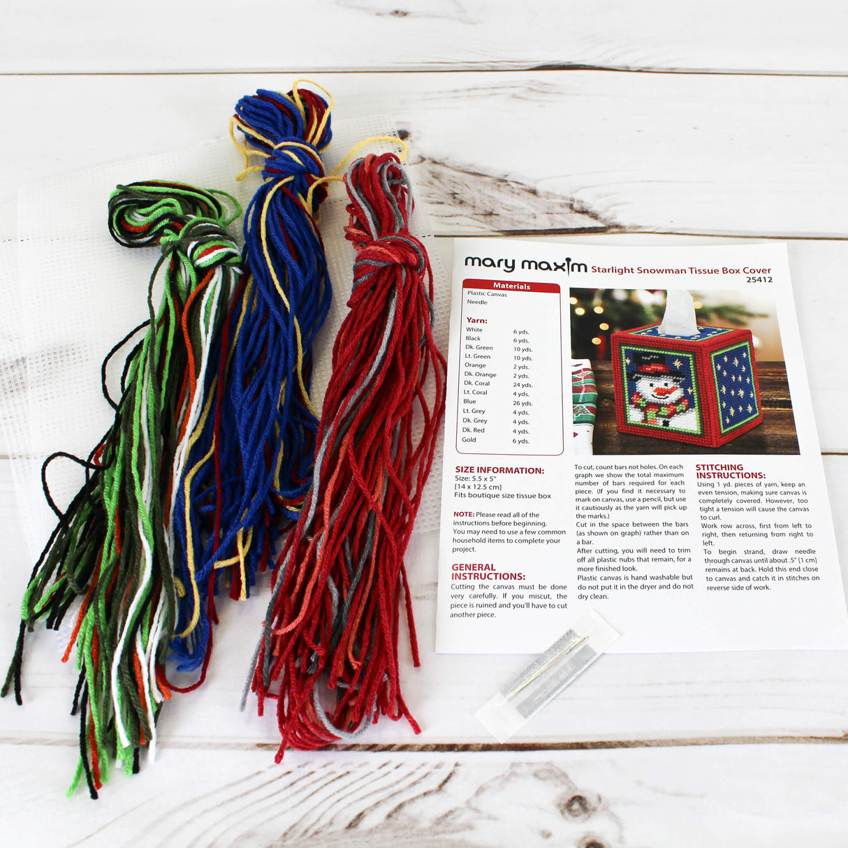 Plastic Canvas Tissue Box Cover with a Snowman in a top hat with a night sky background and red and green trim.