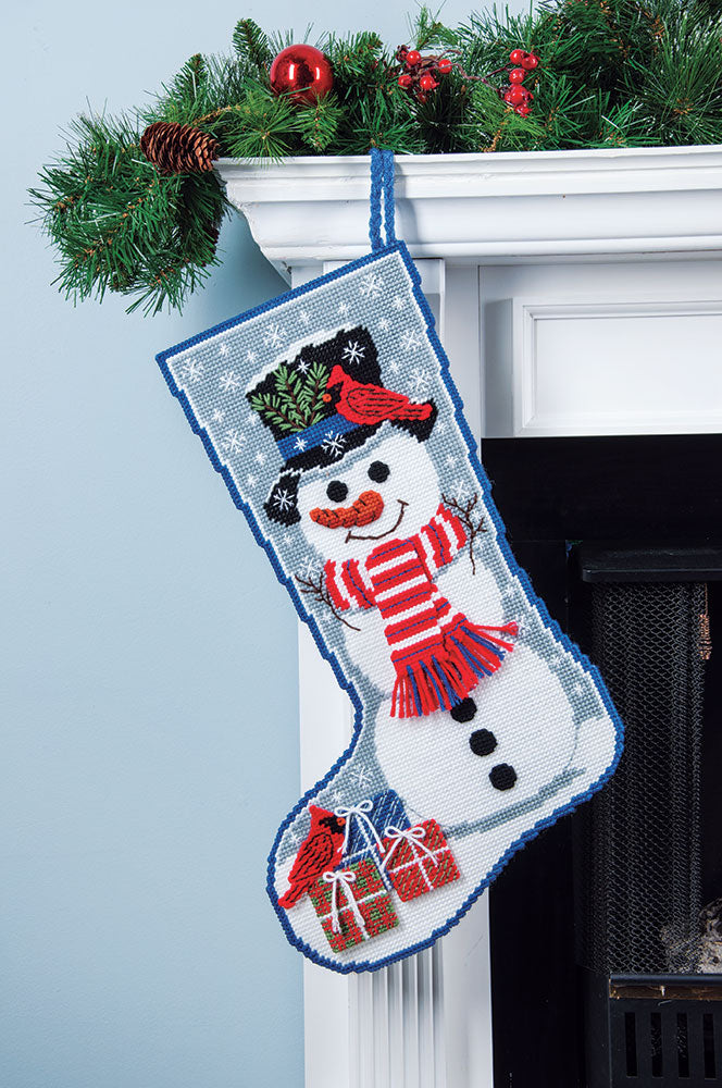 Plastic Canvas Snowman with Cardinal Stocking hanging on a mantle decorated for Christmas.