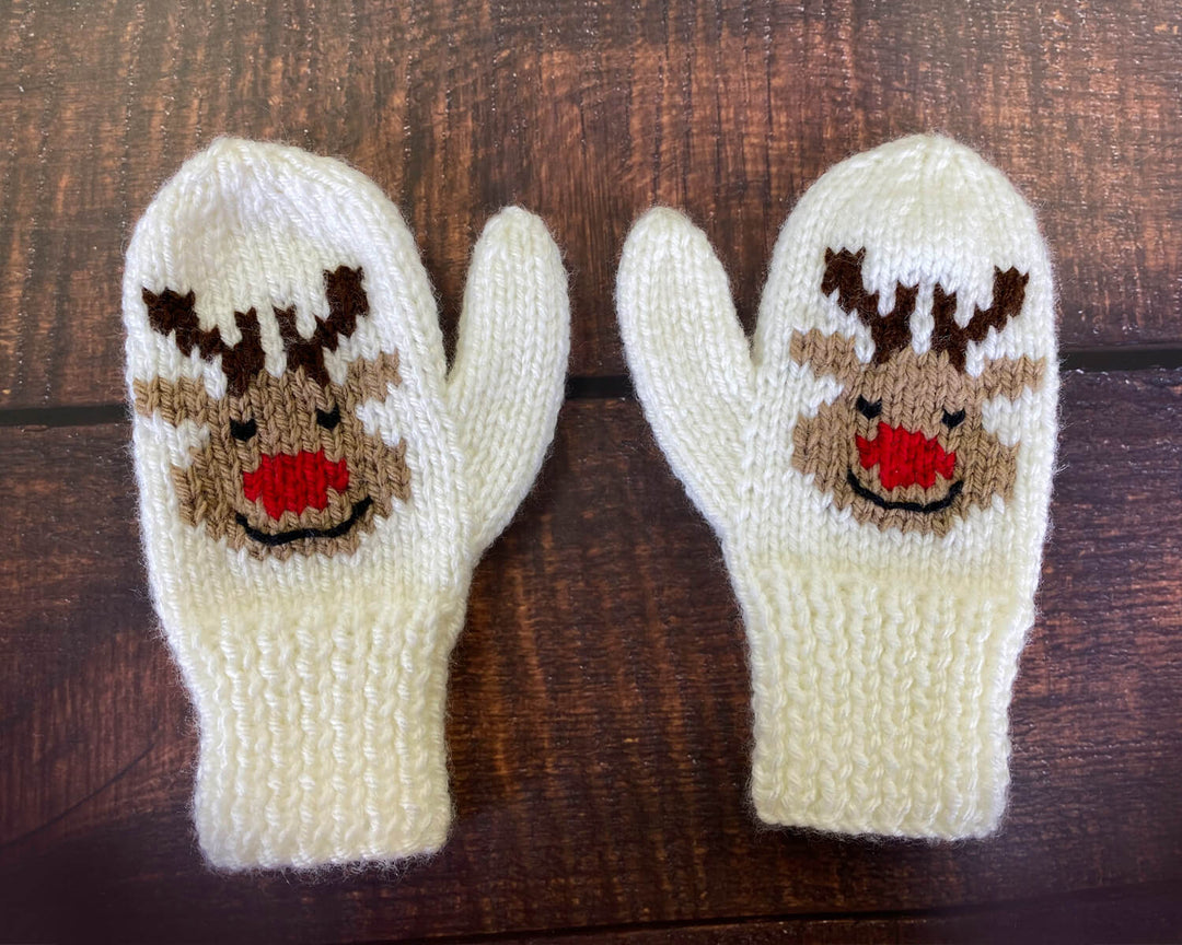 Knit reindeer mittens on a dark wood background