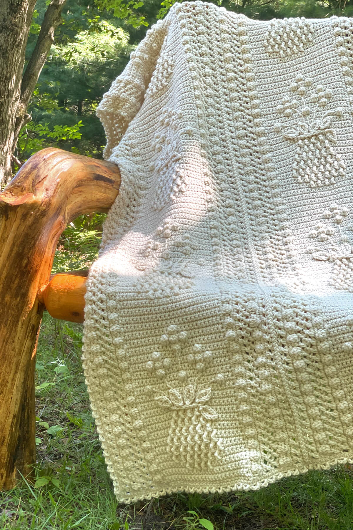Pineapple and Floral Shoppe Afghan on a wooden chair in the woods